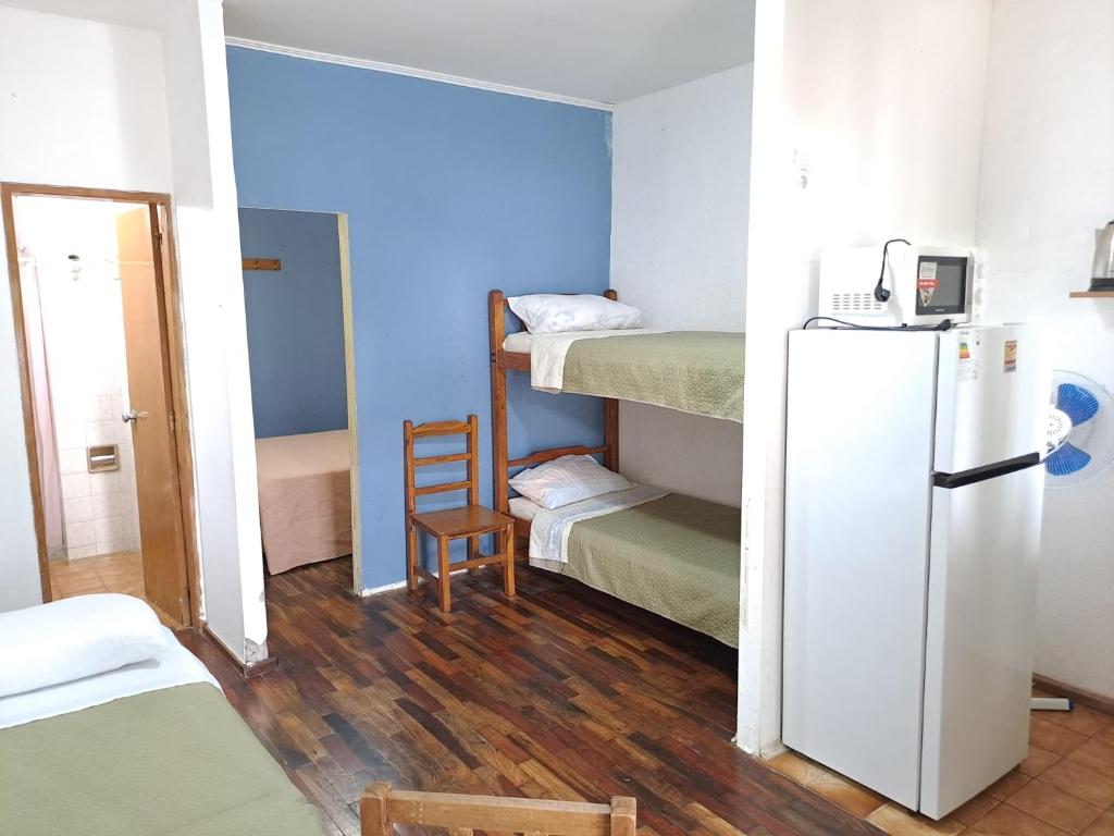 Daymán Apart Hotel في ترماس دل دايمان: غرفة صغيرة فيها ثلاجة وغرفة بها سلم