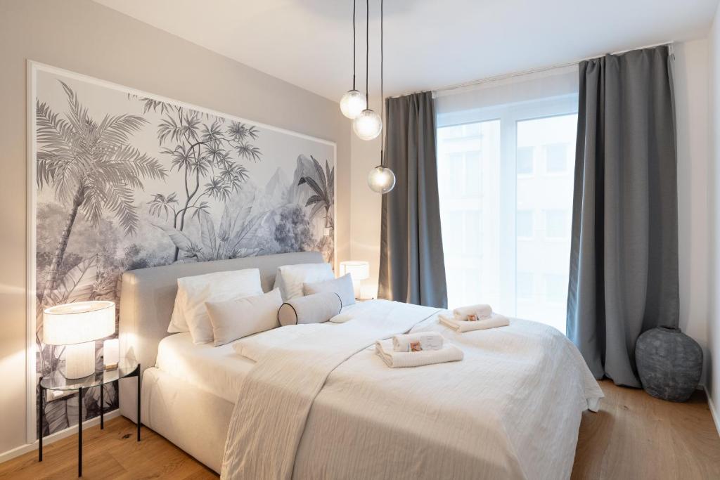 a bedroom with a white bed with two towels on it at Vienna Heights Premium Apartments in Vienna