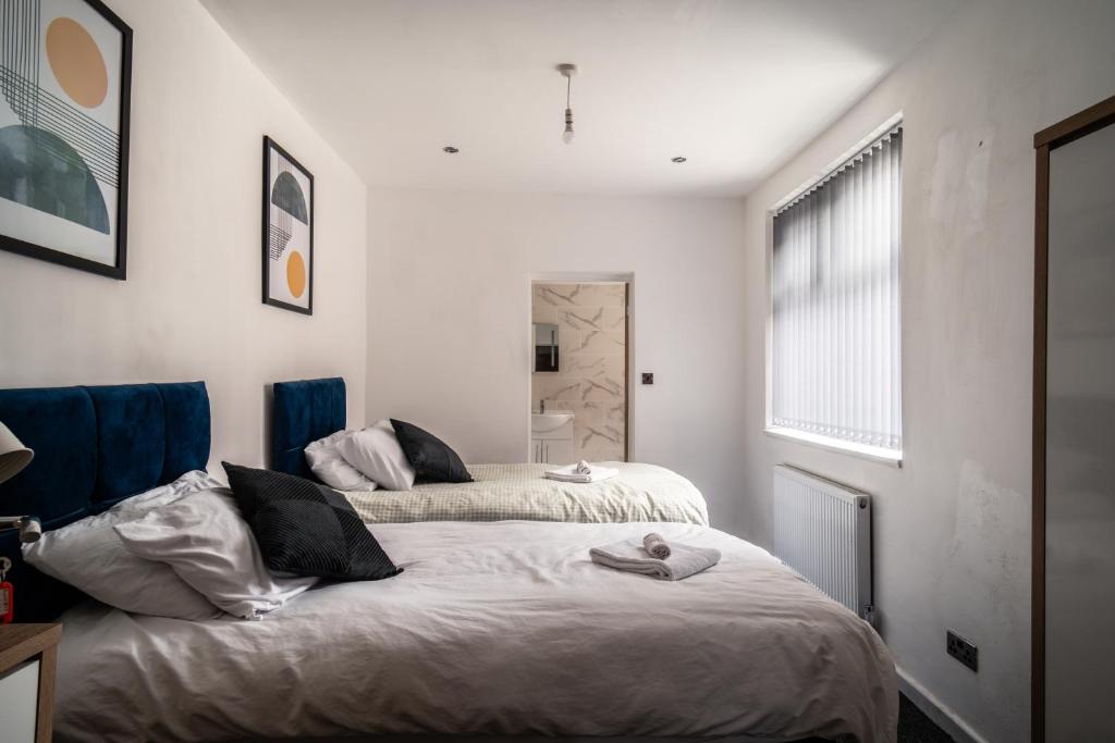 a bedroom with two beds and a window at England's Cozy 1-Bed room Room 1 in Manchester