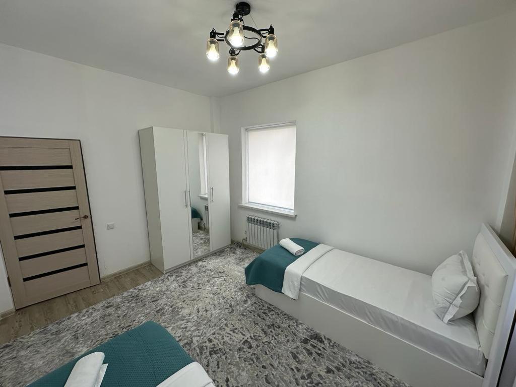 Квартира في Türkistan: غرفة نوم بيضاء بها سرير ونافذة