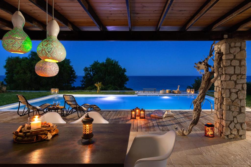 a patio with a table and chairs and a pool at Villa Sevil in Lachania