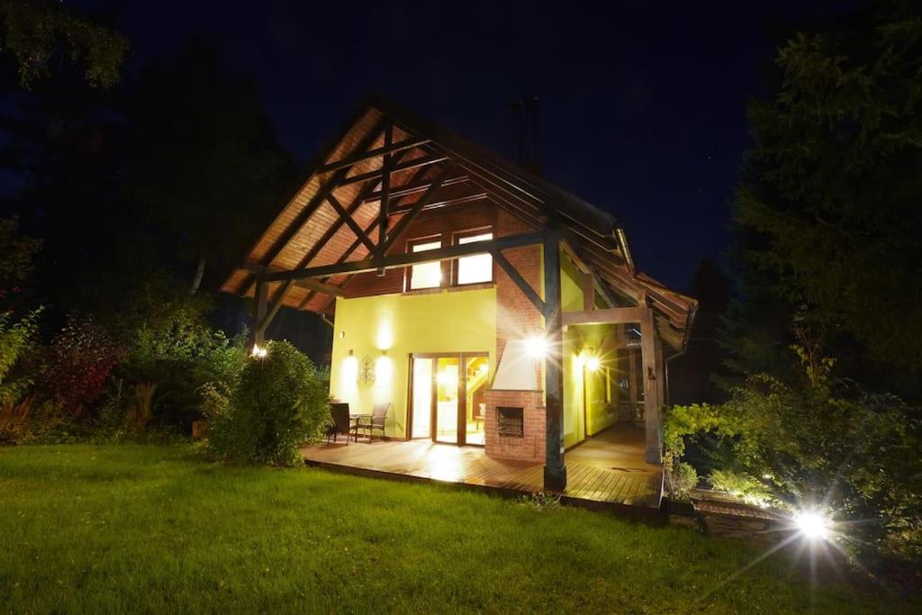 ein kleines Haus mit einer Terrasse in der Nacht in der Unterkunft Kamińsko by Latowisko - Puszcza Zielonka in Kamińsko