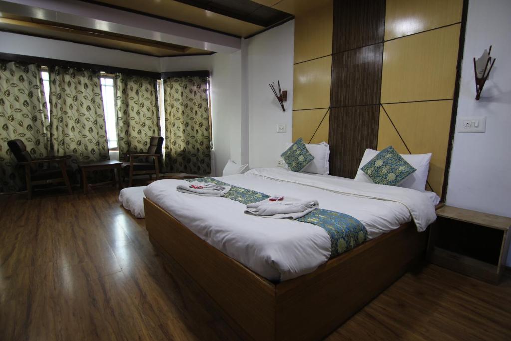 a hotel room with a bed with towels on it at Hotel Rangyul in Kargil