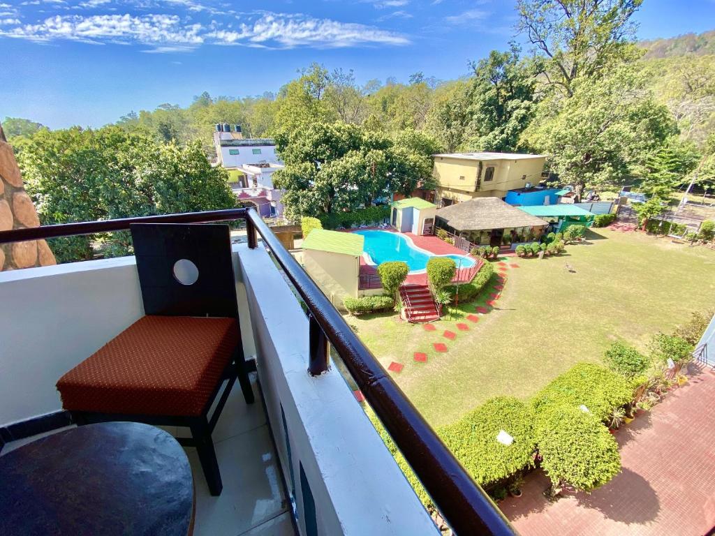 Un balcón con una silla y un patio en Shelton Blu Resort , Jim Corbett en Rāmnagar