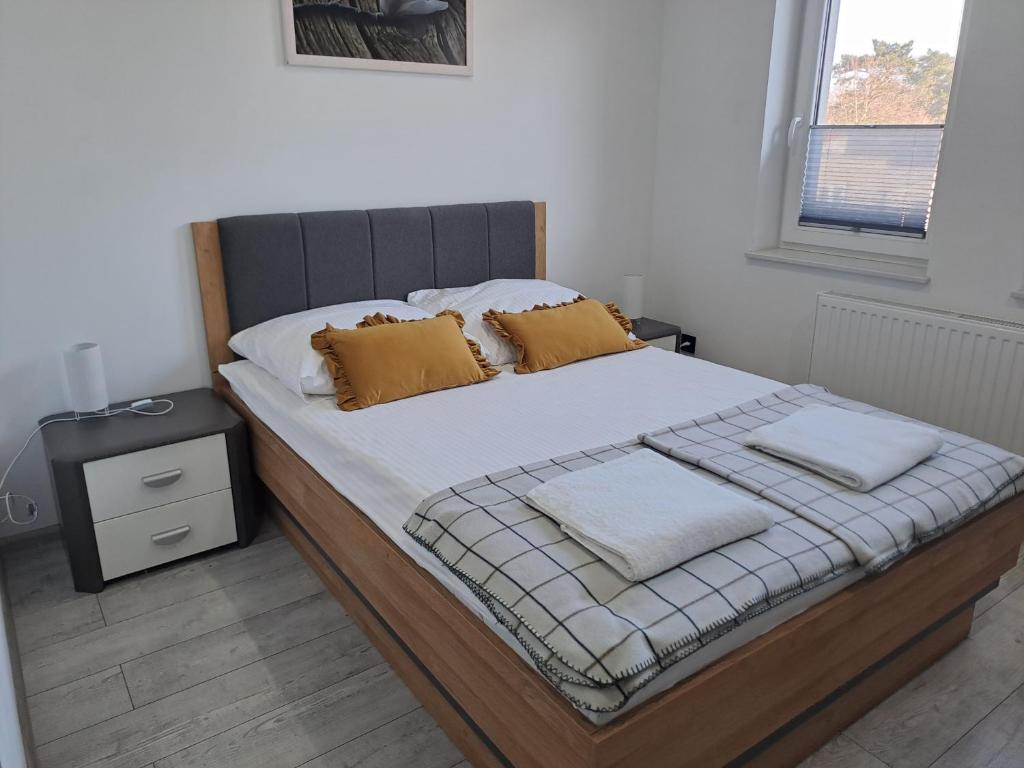 a bed with two pillows on it in a bedroom at Pokoje do wynajęcia in Tomaszów Mazowiecki