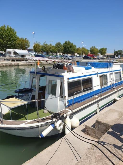 un bateau est amarré à un quai dans l'eau dans l'établissement Studio bateau Narbonne, à Narbonne