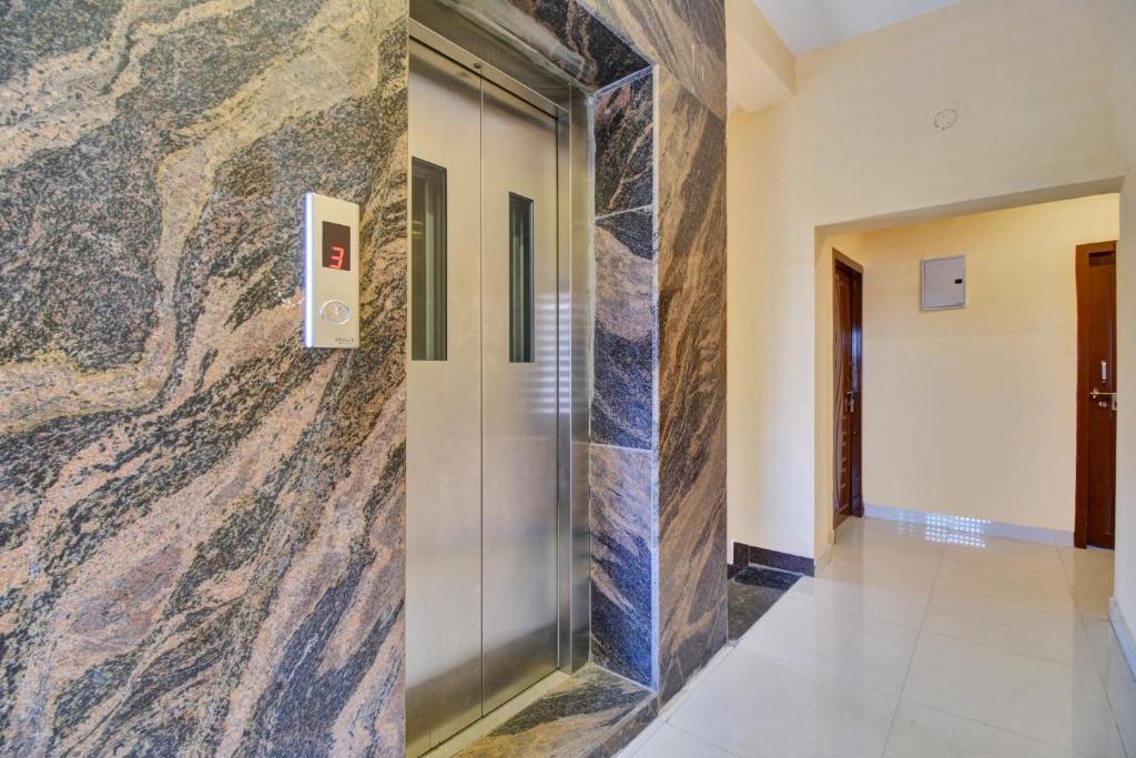 um átrio com uma parede de mármore e um elevador em Super OYO Flagship Rsd Grand em Gunadala