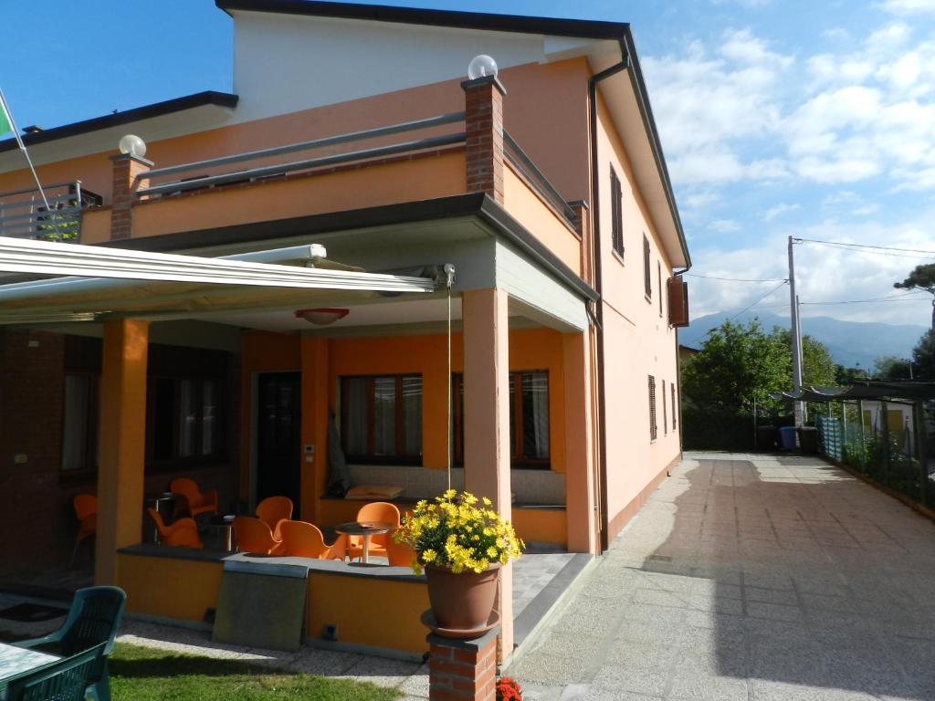 ein Haus mit einer Terrasse mit einem Tisch und Stühlen in der Unterkunft Hotel Sole in Marina di Massa