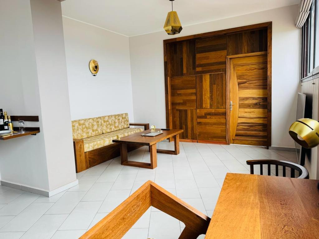 a living room with a table and a wooden door at Amontana Luxury Hôtel in Antananarivo