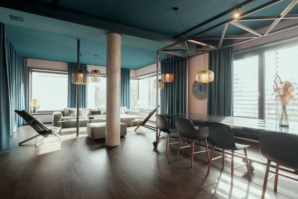 ベルリンにあるNOMADS by Suite030 high class apartments, 1-2 bedroomsの青い壁のリビングルーム(テーブル、椅子付)
