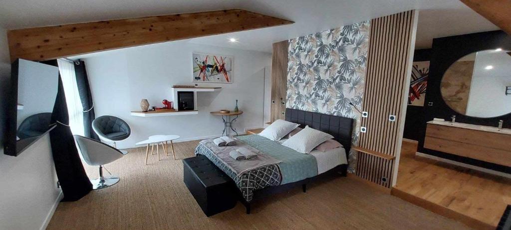 1 dormitorio con cama y espejo en chambre Lilas Domaine Cap de Coste, en Saint-Frajou