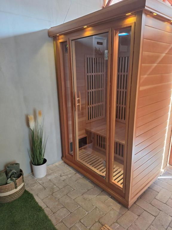 a wooden sauna with a glass door on a patio at Várfal apartman II in Eger