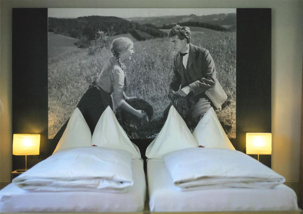 una foto en blanco y negro de un hombre y una mujer de pie junto a una cama en Concept Hotel Landhaus, en Burgdorf