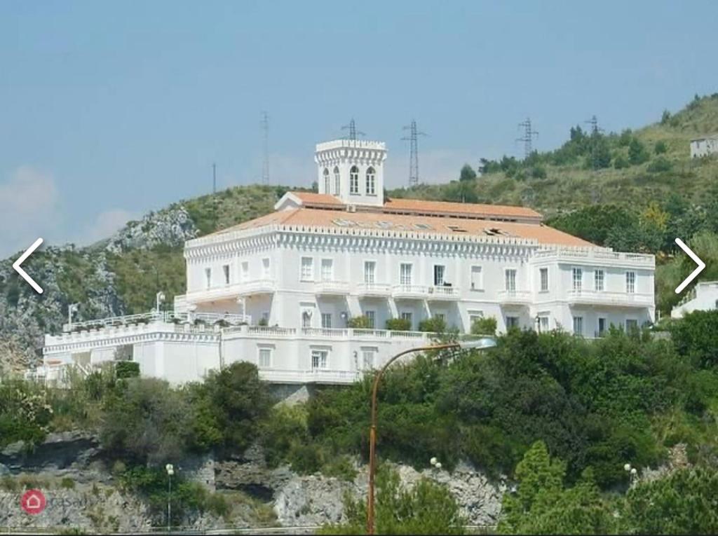 um grande edifício branco no topo de uma colina em Appartamento nel fabbricato denominato Il Castello em Praia a Mare