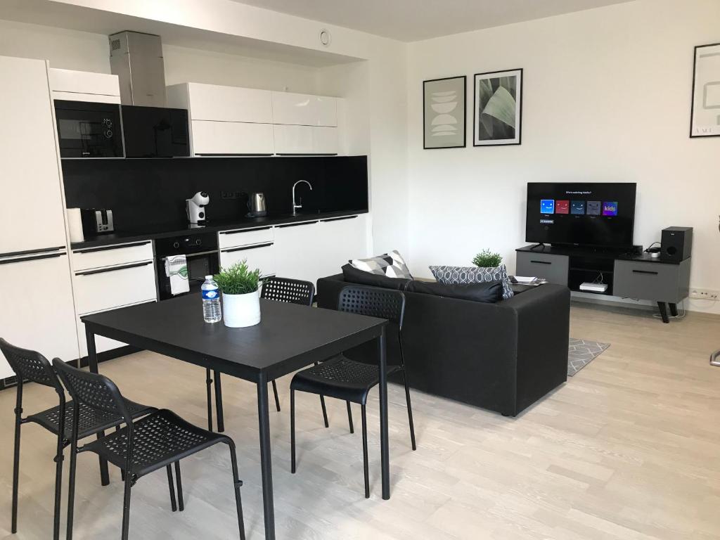 a kitchen and living room with a table and chairs at Apartmantplus02 in Prague