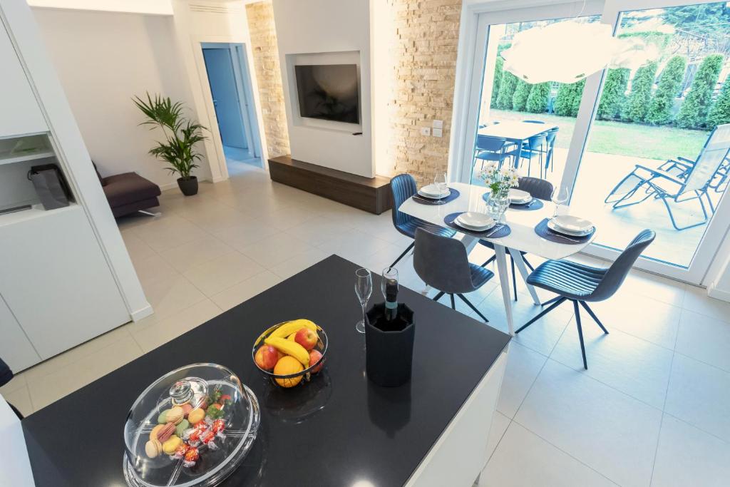 cocina y sala de estar con mesa y un bol de fruta en Casa Aurora, en San Michele allʼAdige