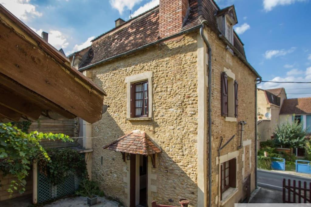 un vieux bâtiment en briques avec un parasol à l'extérieur dans l'établissement Gîte 5 pers en Périgord, à Siorac-en-Périgord