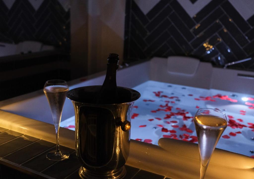 a bottle of champagne in a tub with two glasses at Le Cocon des Layes in Les Essarts-le-Roi