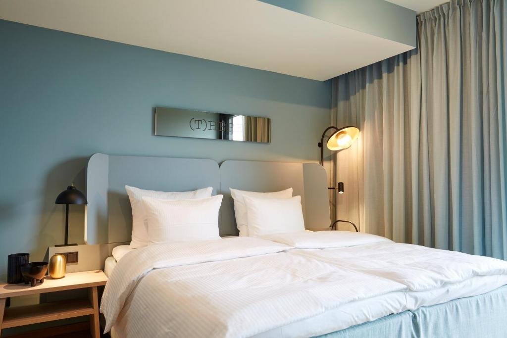 sypialnia z dużym łóżkiem z białą pościelą w obiekcie Scandic Frankfurt Hafenpark w Frankfurcie nad Menem