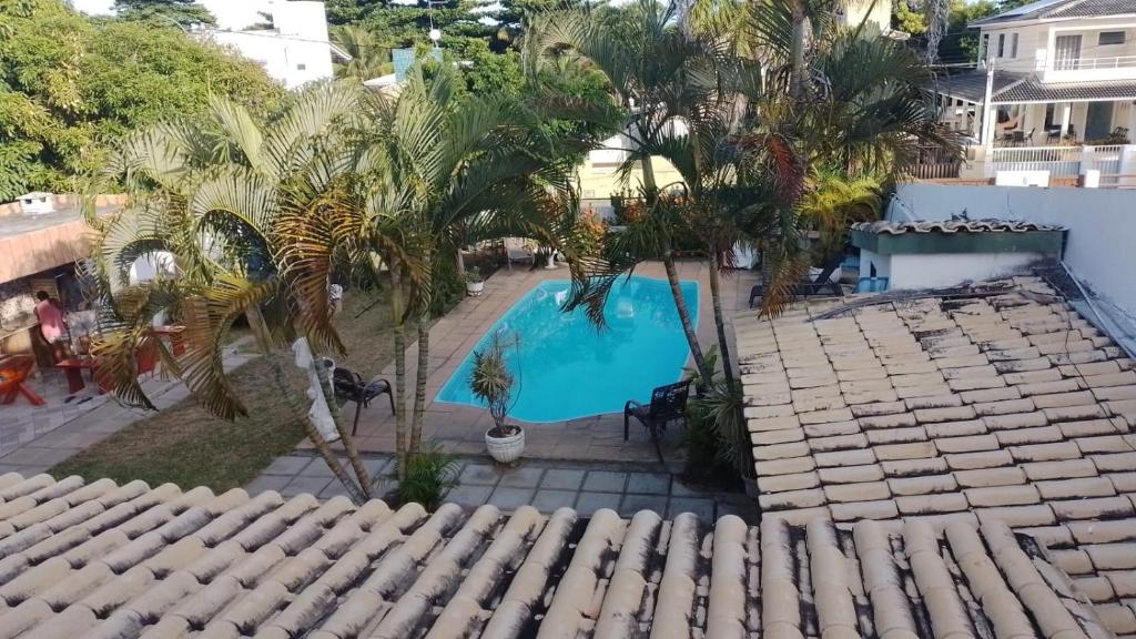uma vista sobre uma piscina com palmeiras em Casa 3/4 Guarajuba BA em Camaçari