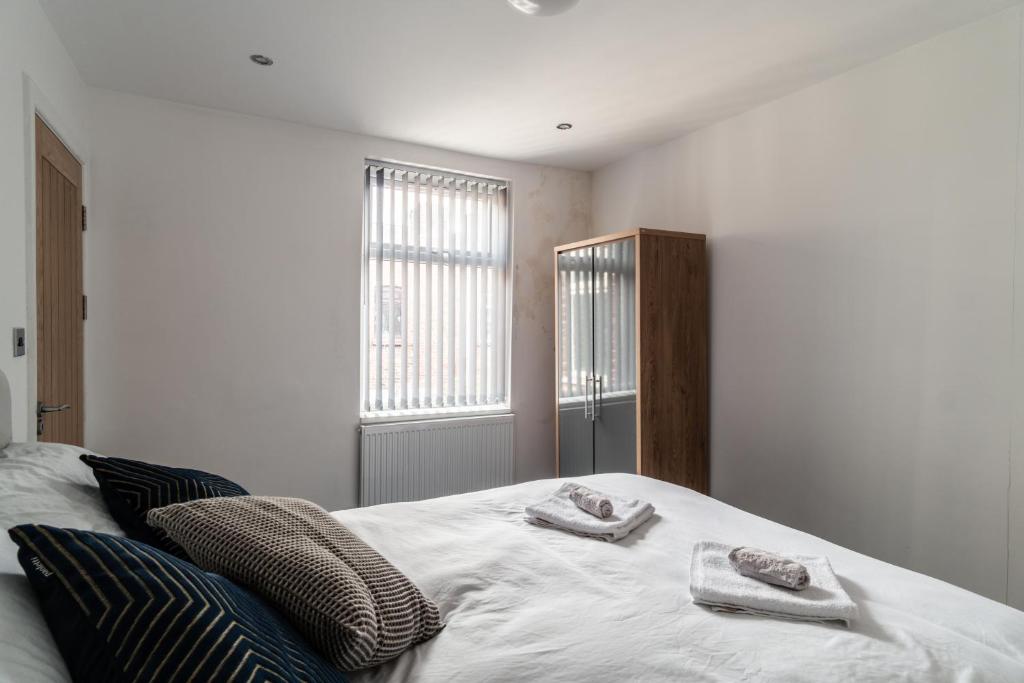 a bedroom with a bed with two towels on it at Harmony House: Shared Spaces Room 3 in Manchester