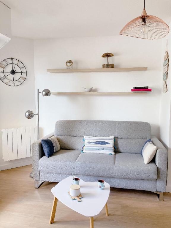 un salon avec un canapé et une table dans l'établissement Nouveau * Ty Lévenez *pour 2 vacanciers * Parking, à Carnac