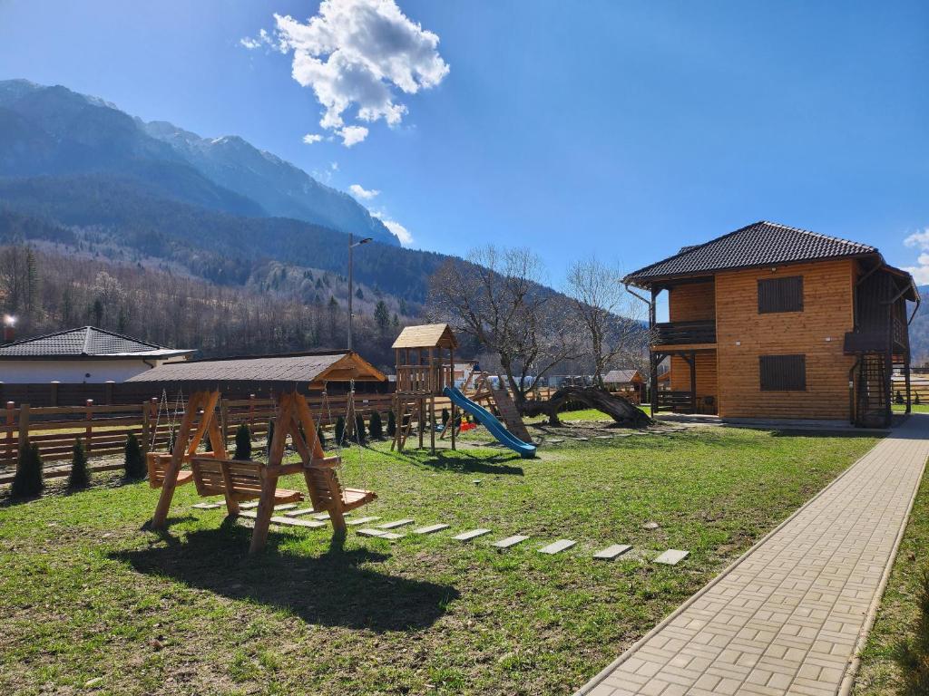 a playground in front of a log cabin at Apartamente Creasta Craiului in Zărneşti