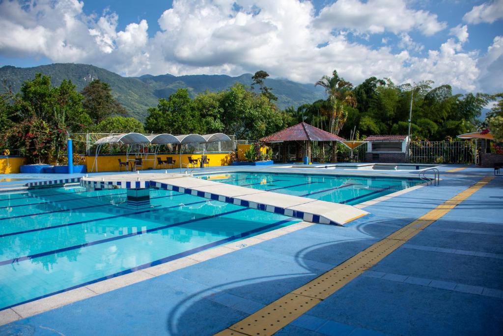 une grande piscine avec des montagnes en arrière-plan dans l'établissement Hotel Karlaká Calarcá Quindio, à Calarcá