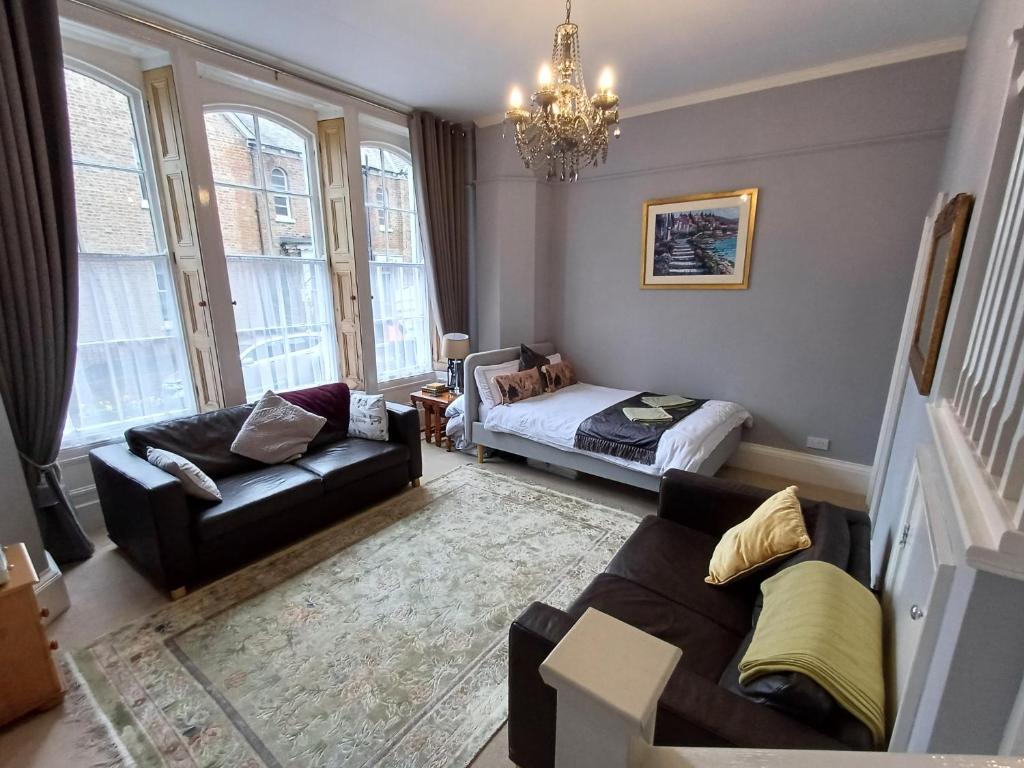 a living room with a couch and a bed at Abbotts Mews Apartment York City Centre in York