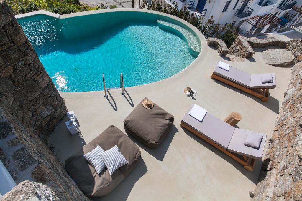 an overhead view of a swimming pool with chaise lounges at Breathtaking 6 Bed in Platis Gialos in Platis Gialos