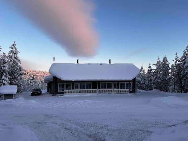 a building with a snow covered roof in the snow at Ruka Cottage in Kuusamo