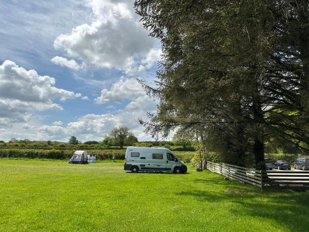 a white van parked in a field next to a tent at Pitch 1 - Rising Sun Inn Campsite in Altarnun
