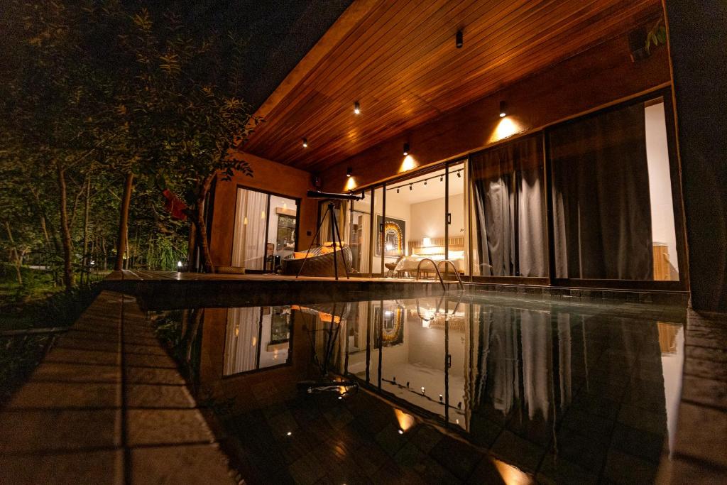 uma casa com piscina à noite em Quinta dos Goyazes Eco Boutique pra curtir a dois em Pirenópolis em Pirenópolis