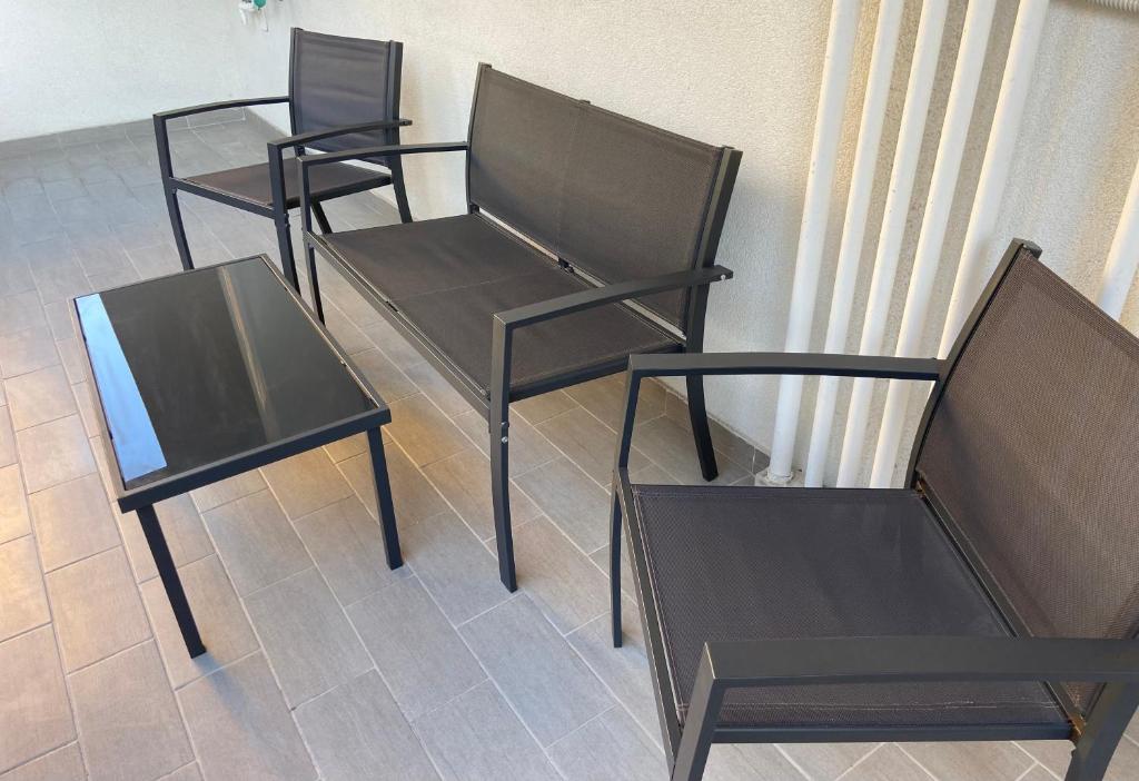 three black chairs and a table in a room at Bari Lory’s Home in Bari