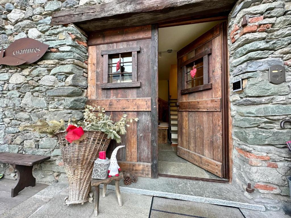 ニュスにあるMaison Rosset agriturismo, CAMERE, appartamenti e spa in Valle d'Aostaの木の扉付きの石造建築の入口