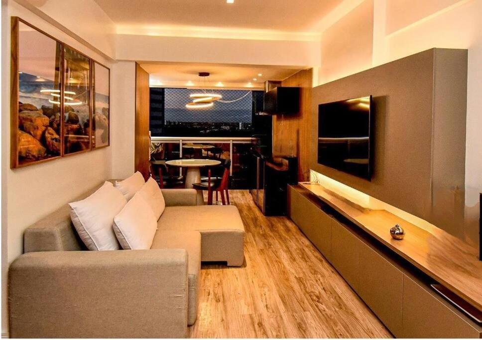 a living room with a couch and a tv in it at Salvador Prime Premium 2 suítes in Salvador