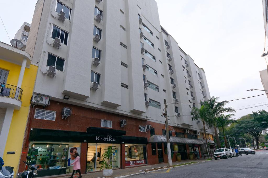 a tall building on a city street with a store at Fênix Hotel Bom Retiro in Sao Paulo