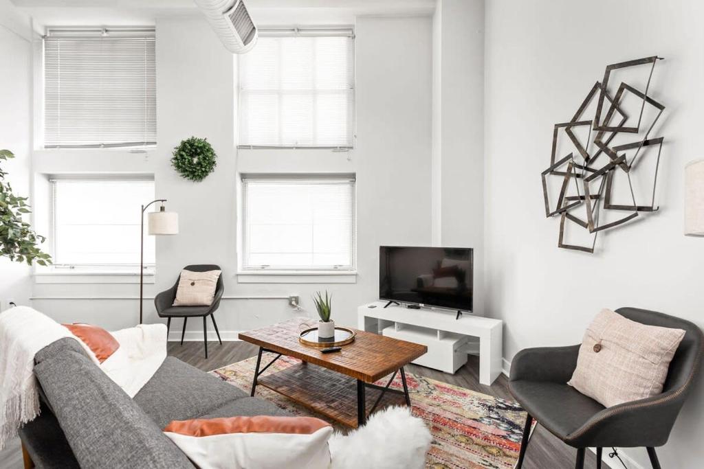 una sala de estar con un sofá y una mesa en Modern Downtown Apartment 2BR 2BA by CozySuites, en Indianápolis