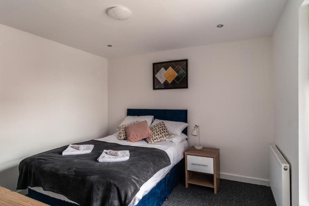 a small bedroom with a bed and a table at Shared Comfort, Singular Charm Room 4 in Manchester