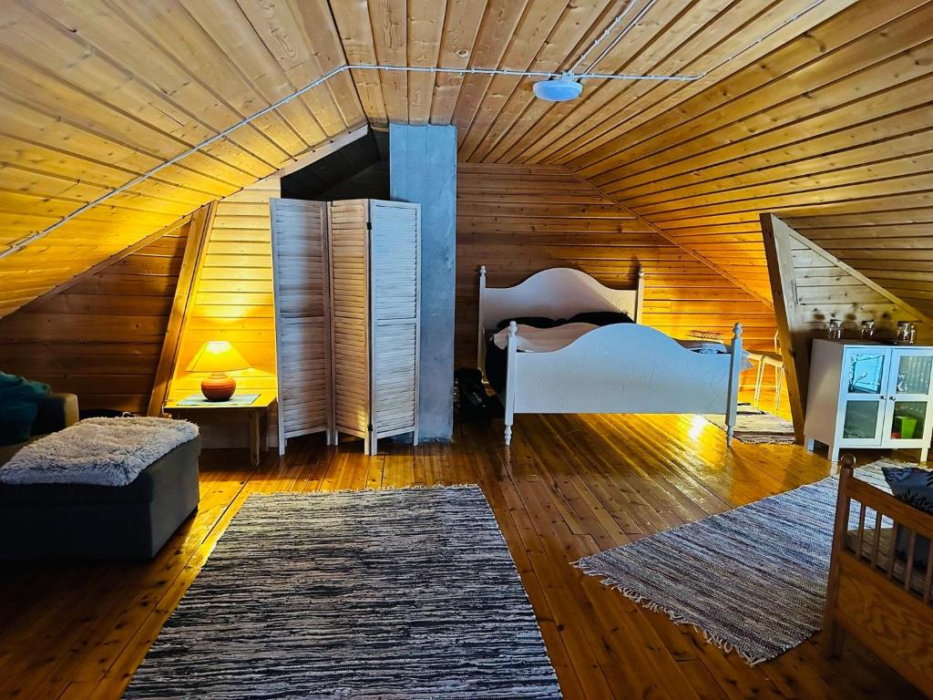 a bedroom with a bed in a wooden ceiling at Lakeside Log Villa Edith in Rovaniemi
