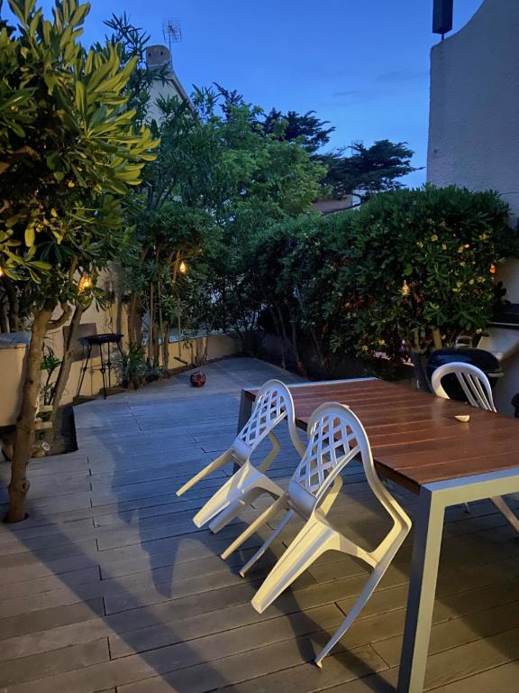 une table en bois et deux chaises assises à côté d'une table dans l'établissement SCI Eylo, à Leucate