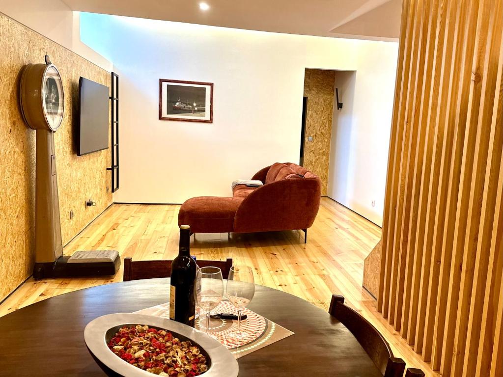 uma mesa com uma garrafa de vinho e uma pizza em A casa na Estrela em Lisboa