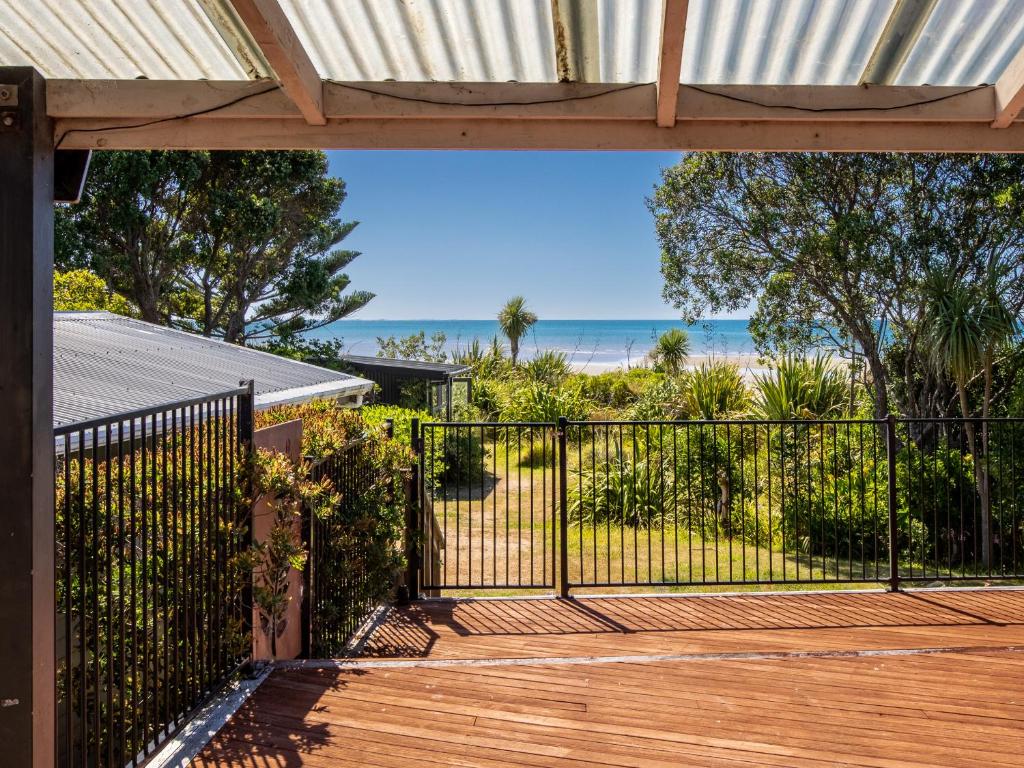 eine offene Veranda mit Blick auf den Strand in der Unterkunft Godwit Cottage - Pākawau Beachfront Holiday Home in Pakawau