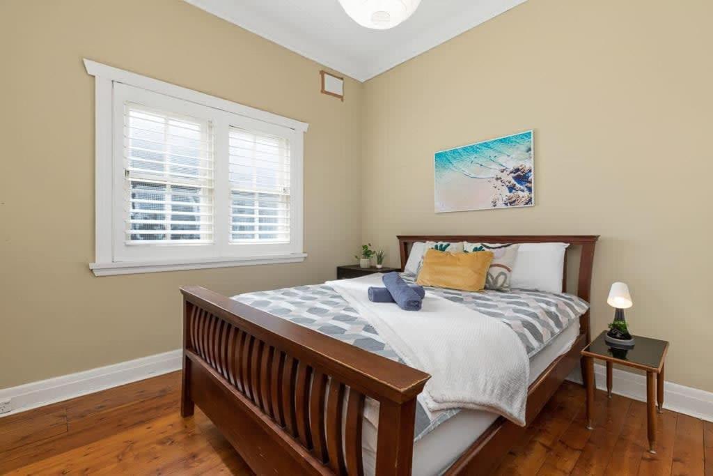 a bedroom with a large bed and a window at Cozy house in Kensington near UNSW & Light railway in Sydney