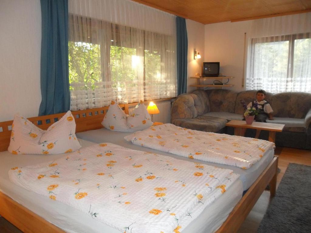 a bedroom with a large bed and a living room at Mattenhof in Zell am Harmersbach