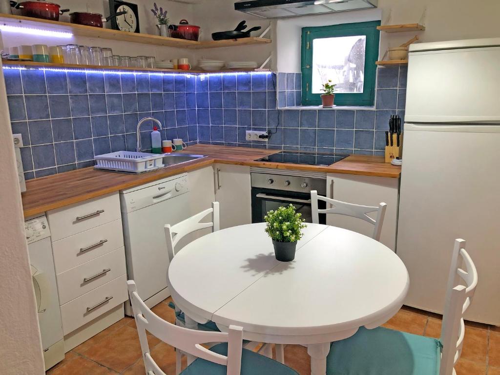 a kitchen with a white table and a white refrigerator at ALOJAMIENTO NO ACTIVo in Moclín