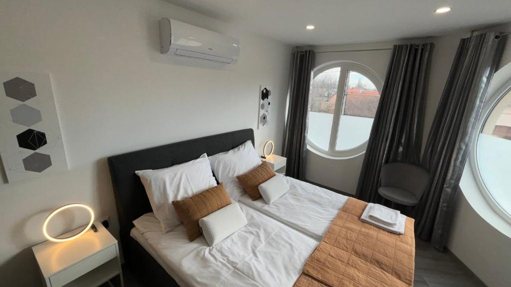 Un dormitorio con una cama con una ventana grande. en Natasa Apartman, en Villány