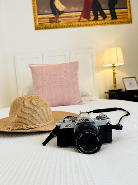 a camera and a hat sitting on a bed at Guest House Camilla in Alghero
