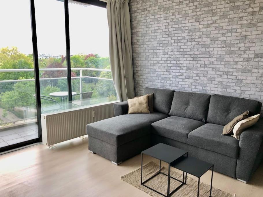 a living room with a couch and a brick wall at Antwerp Central Park in Antwerp