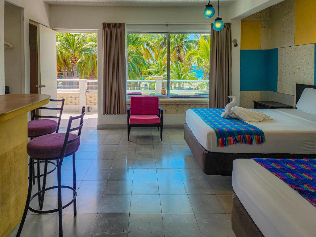 una habitación de hotel con 2 camas y un bar en Antillas, en Isla Mujeres